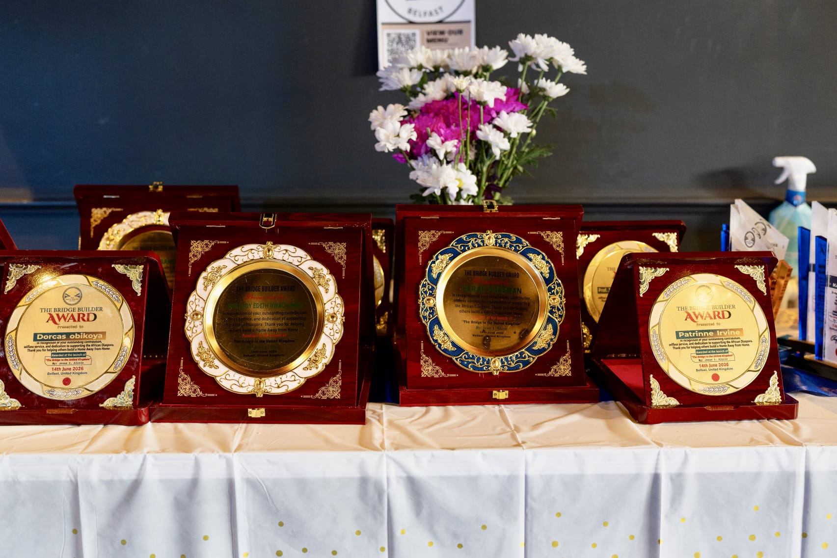 Award plaques waiting on the table beside the flowers